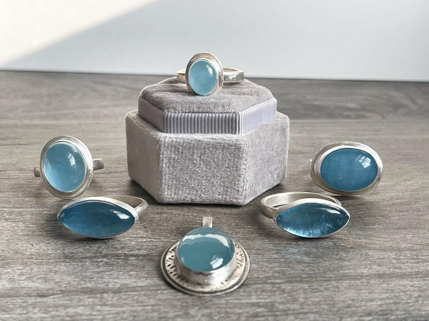 Set of silver rings with blue stones on a wooden surface