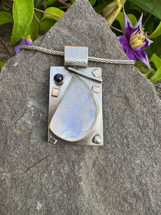 Handmade sterling silver moonstone teardrop pendant with sapphire, front view