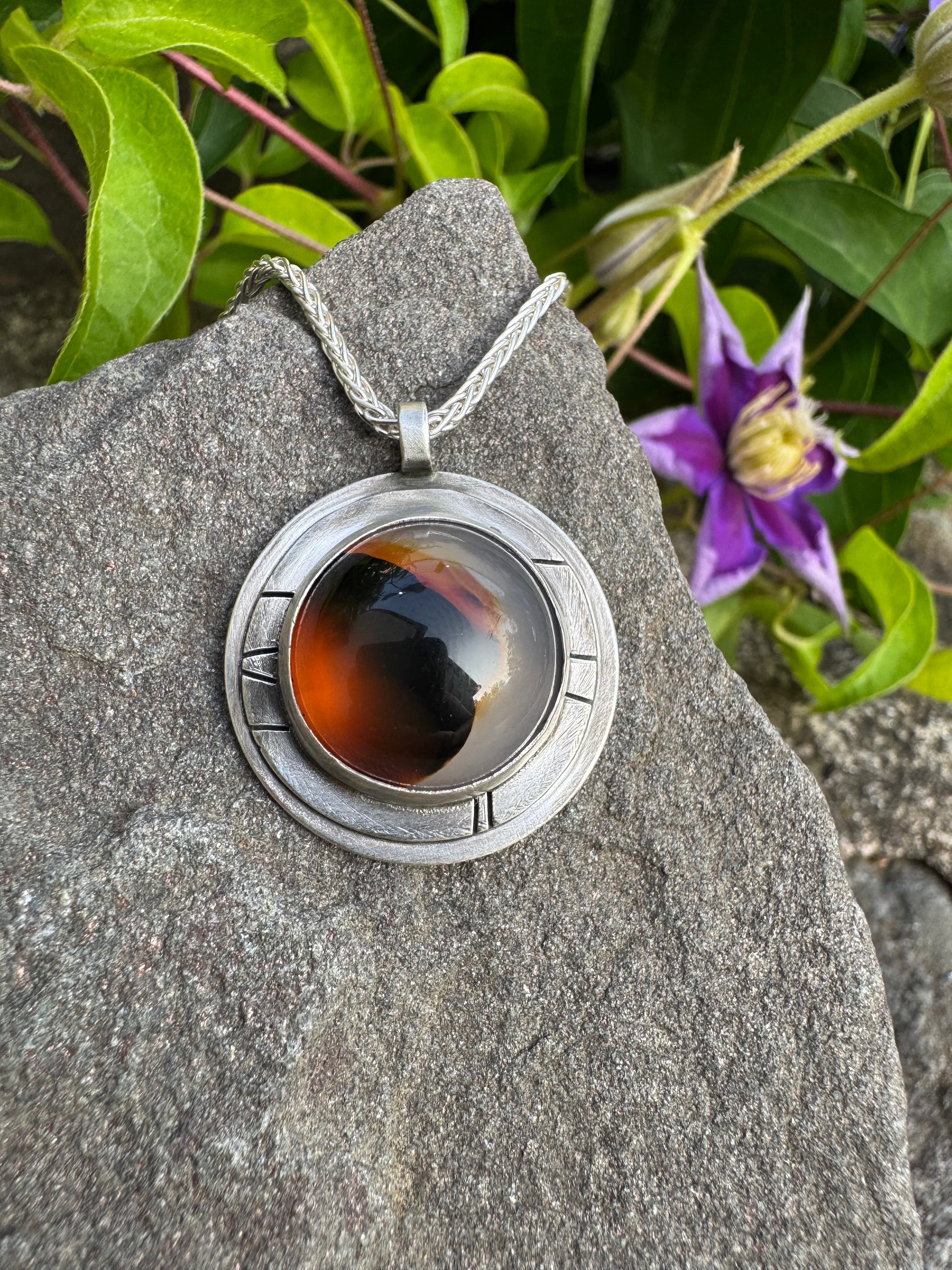 Handmade sterling silver Montana agate pendant in sterling silver with engraved panels, close-up view